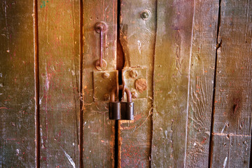 The old wooden gate is padlocked