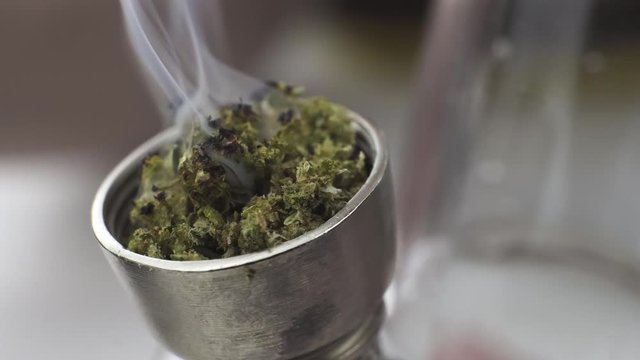 Close-up of smoking medical marijuana with bong, indoors. Macro of smoke cannabis at home. Cannabis is a concept of herbal medicine
