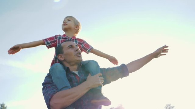 Happy family father and son play with arms wide apart. The game of the plane boy machin hands depicting the wings of an airplane. Teamwork. Family games. Happy family life concept