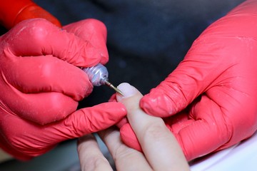 Female hand in process of professional manicure in a beauty salon close-up. Beauty, health, fashion concept.