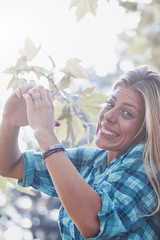 Young woman outdoors making heart - shape symbol for love and romance.