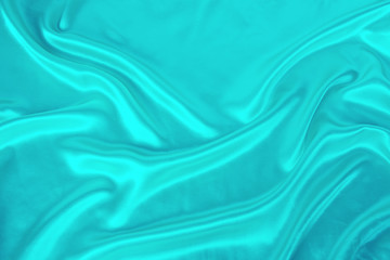soft folds on delicate turquoise shining silk, luxury concept, background for the designer, horizontal, close-up, copy space