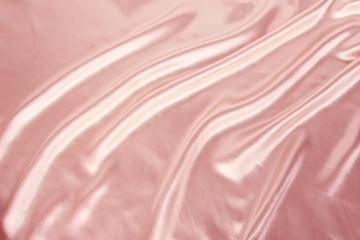 Fototapeta premium soft folds on delicate pink shining silk, luxury concept, background for the designer, horizontal, close-up, copy space