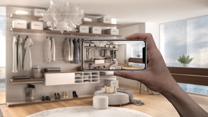 Hand holding smart phone, AR application, simulate furniture and interior design products in real home, architect designer concept, blur background, modern bedroom with walk-in closet