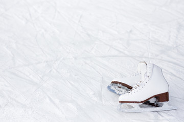 close up of figure skates and copy space over ice with marks from skating