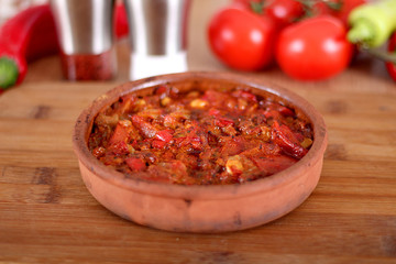 Serving fresh meat in earthenware dish with green pepper