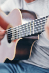 Man playing acoustic guitar in the living room.