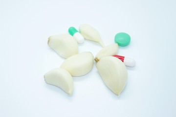 Cloves of garlic pills capsules located on a white background