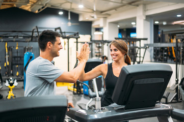 Fototapeta na wymiar Adult couple running on a treadmill in a gym