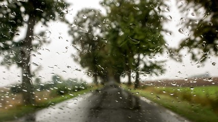 Rain droplets on car windshield . Look on the water drops on car windshield from inside the car at...