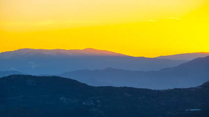 yellow evening sky and mountain ridge silhouette, twilight scene, good mountain background