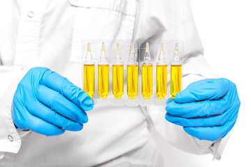 In the hands of a scientist holds the results of laboratory research while the hands of a chemist are dressed in medical gloves,Yellow liquid in test tubes Biochemistry industry