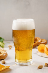 Light beer glass and snack variety around.