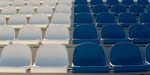 Bleachers in a sports stadium. Red and white seats in a large street stadium.