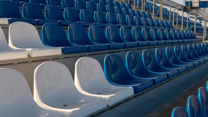 Bleachers in a sports stadium. Red and white seats in a large street stadium.