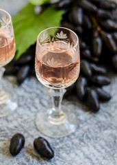 Traditional Italian grappa or liquor and grape.  Wine and grape.
