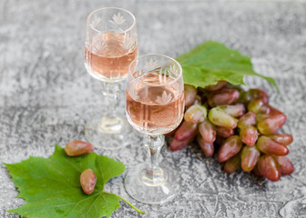 Traditional Italian grappa or liquor and grape.  Wine and grape.