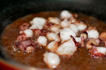 The process of frying chopped octopus on a hot pan