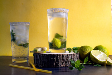 mojito, refreshing mojito with limes on a yellow background