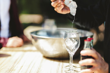 Waiter serving ice in glasses