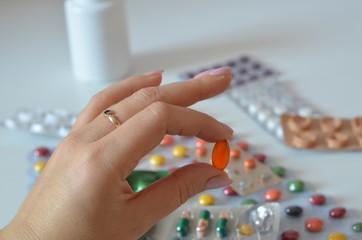 selective focus Medicine pills or capsules in hand, palm or fingers. Drug prescription for treatment medication. Woman, young female, person taking vitamin, painkiller, antibiotic