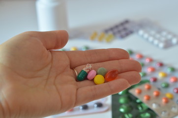 selective focus Medicine pills or capsules in hand, palm or fingers. Drug prescription for treatment medication. Woman, young female, person taking vitamin, painkiller, antibiotic