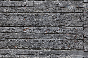 Background wall of horizontal charred black boards in the form of coals. Fire and extinguishing.