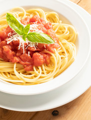 close up on dish with spaghetti tomato and basil