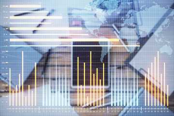 Double exposure of forex chart and world map on digital tablet laying on table background. Concept of market analysis