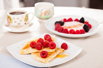 breakfast of pancakes with fresh raspberries on table