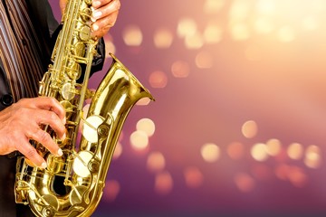 Fototapeta premium Close-up man playing on saxophone on blurred background