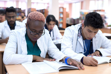 A group of multi-ethnic racial students at a medical university. We sit at the table, we write, we read, we pass the exam