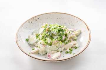 Salad fresh cucumbers and radish with sour cream and onion isolated on white background