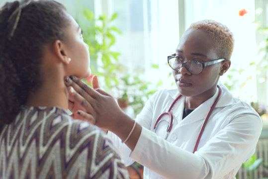 african female doctor watching patient with sore throat