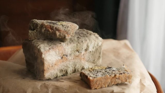 slice of bread falling on moldy bread, particles of mold slow motion, swirl, floating