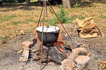 Cooking barbecue and fish soup on a bonfire on a picnic outside the city. Summer, 2019.