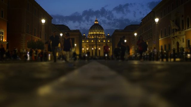 Time lapse of San Pietro St. Peter cathedral in Rome, Vatican, at night while people passing in Conciliation street. Travelling in Italy.
