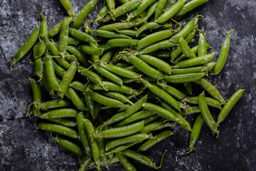 closeup of green peas, on an abstract black and white background, in a rustic style