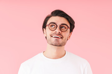 Image of handsome cheerful man wearing eyeglasses smiling and looking aside at copyspace