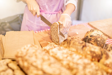 Woman hands slicing home made bread.