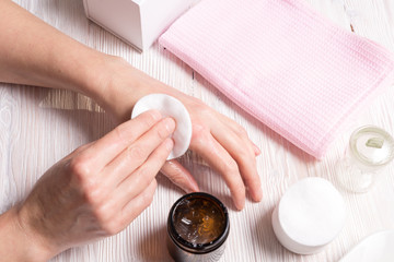Woman making care cream mask for hands
