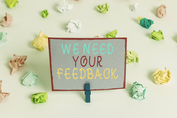 Writing note showing We Need Your Feedback. Business concept for criticism given to say can be done improvement Colored crumpled paper empty reminder white floor clothespin