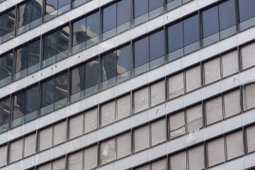 Fototapeta premium Glass windows and concrete walls in the daytime. Arcitectural fragment of modern building in Bangkok, Thailand.