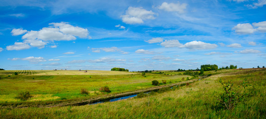 Beautiful panoramic landscape with river and golden fields