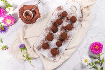 Fine chocolate truffles on white ceramic plate.