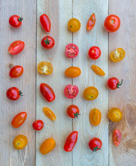 Colorful red, orange and yellow cherry tomatoes on wooden background.