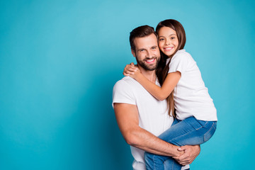 Portrait of lovely man with brunet hair cut holding his daughter having long hair wearing white...