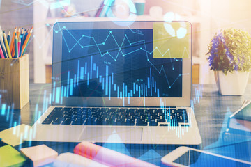 Financial graph colorful drawing and table with computer on background. Multi exposure. Concept of international markets.