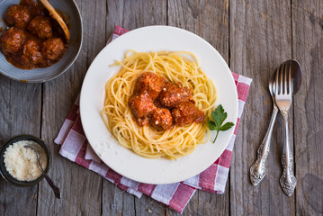 Delicious spaghetti with meatballs in tomato sauce on dark background, italian cuisine