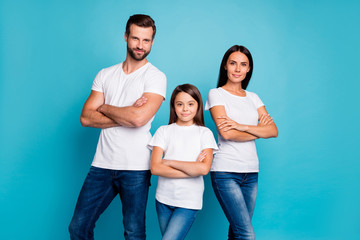 Portrait of focused family with brunette hair crossing their hands looking wearing white t-shirt...